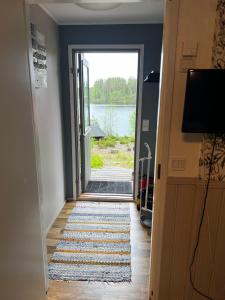 een gang met een deur met uitzicht op een meer bij Huvikumpu in Orivesi