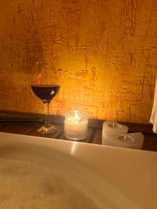 a candle and a wine glass on a bath tub at Pousada Portal do Céu in Visconde De Maua