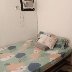 a bedroom with a bed with flowers and a fan at Love Bk Siargao Homestay in General Luna