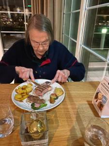 een vrouw die aan een tafel zit met een bord eten bij Oomes Huus - Sleep by Hästens, Wake with Coffee in Den Hoorn +240 foto's