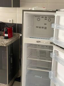 een lege koelkast met de deur open in een keuken bij le riffe in Nador