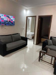 een woonkamer met twee banken en een flatscreen-tv bij le riffe in Nador