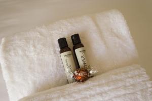 two bottles of moisturizers sitting on a white towel at Story Haus in Stellenbosch +28 photos