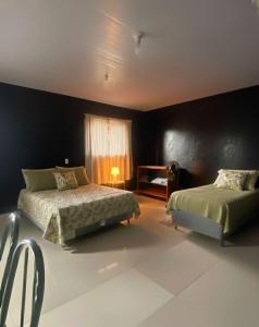 una camera da letto con due letti e una finestra di Loft ZN Natal próx Norte Shopping Genipabu a Natal