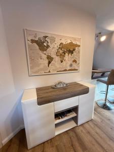 a white desk with a world map on the wall at Ferienwohnung Bernsteinsucher städtische Bestlage in Ribnitz-Damgarten