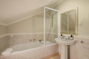 een badkamer met een wastafel en een bad en een wastafel bij Story Haus in Stellenbosch +83 foto's