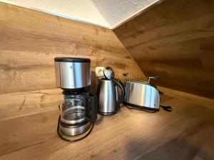 two coffee pots and pans sitting on a wooden floor at Ferienwohnung Bernsteinsucher städtische Bestlage in Ribnitz-Damgarten +6 photos