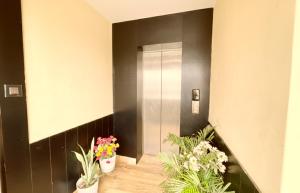 ein Flur mit Topfpflanzen und einem Aufzug in der Unterkunft Sea View From Rooftop The AOP Luxuaray Hotel - Jagannath Temple - Sea Beach - Lift-Parking And Restaurant Facilities - Fully Air Conditioning Luxuary Rooms - Best Hotel In Puri in Puri