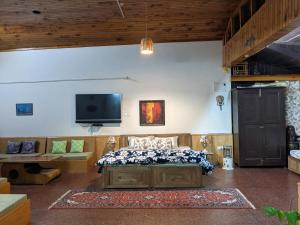 a bedroom with a bed and a flat screen tv at Nalze Khar in Raogi