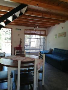 un soggiorno con un tavolo e un divano blu di Casita Santa Elena 1 a Trapiche