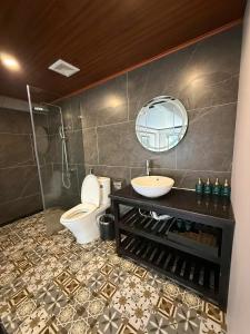 un bagno con un water, un lavandino e uno specchio di Sapa Emerald Hotel a Sa Pa