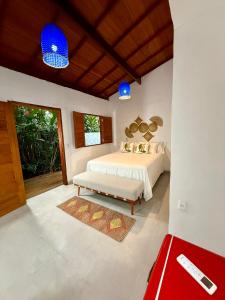 una camera con letto bianco e luci blu di Cantinho da Cineka a Caraíva Altre 36 foto