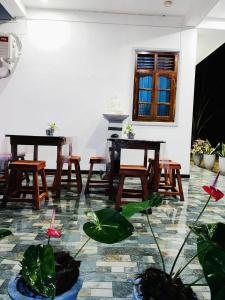 een kamer met tafels, stoelen en planten bij S & S Homestay in Walliwala East