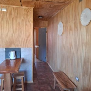 a room with a wooden table and a bench at Cabaña Elizabeth in Cochrane +3 photos