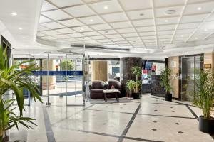 een kantoorlobby met een bank en planten bij Al Thill Hotel in Mekka