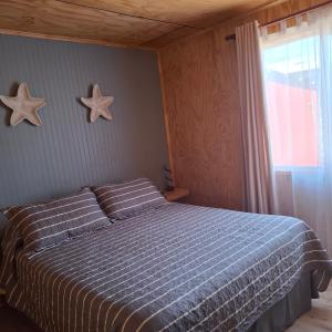 ein Schlafzimmer mit einem Bett mit zwei Sternen an der Wand in der Unterkunft Cabaña Elizabeth in Cochrane