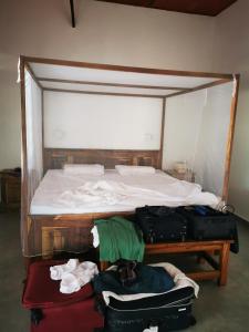 een bed met een hoop bagage ernaast bij Flower Garden House in Sanyang +22 foto's