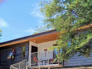 een zwart huis met een balkon en een boom bij Cabañas Los Volcanes Ensenada Puerto Varas in La Ensenada