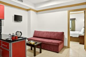 een woonkamer met een rode bank in een kamer bij Al Thill Hotel in Mekka