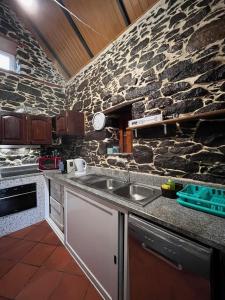 a kitchen with a sink and a stone wall at Casa Duque in Santana with AC and heating in Santana +28 photos