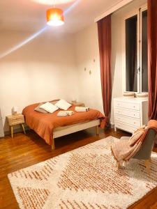 a bedroom with a bed with orange sheets and a rug at Grande maison centre ville in Laval
