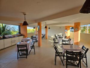 een restaurant met tafels en stoelen en een keuken bij Pousada Tabatinga in Conde