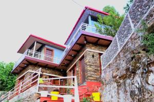 a house on the side of a mountain at The Himalayan Majesty Hotel in Chopta +4 photos