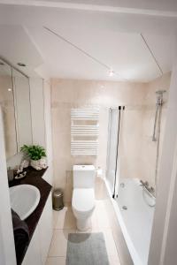 a white bathroom with a toilet and a sink at Studio Fifty9 in Knokke-Heist