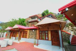 a house with a red roof and some chairs at The Himalayan Majesty Hotel in Chopta