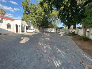 eine Einfahrt mit einem auf der Straße geparkten Auto in der Unterkunft Monica's Guesthouse in Welkom