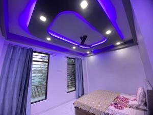 a bedroom with a purple ceiling with a bed and a window at Revanta Home Stay in Anandpur Sāhib