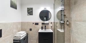 un bagno con doccia, lavandino e specchio di Praga Studio Apartments a Varsavia