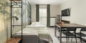 una camera da letto con un letto, una scrivania e un tavolo di Praga Studio Apartments a Varsavia