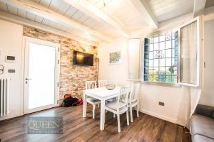 een eetkamer met een witte tafel en stoelen bij QUEEN HOME Emanuelle in Venetië