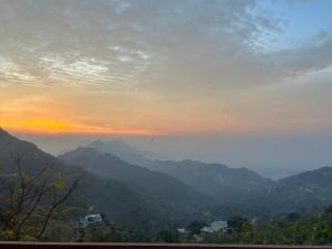 a view of a mountain range with a sunset at Revanta Home Stay in Anandpur Sāhib