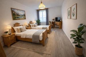 a large bedroom with two beds and a desk at Pension Ursula in Pfaffstätten