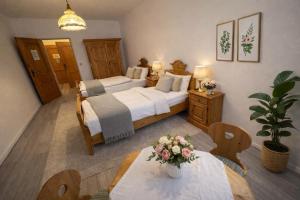 a bedroom with two beds and a table with flowers on it at Pension Ursula in Pfaffstätten