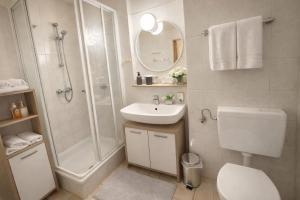 a bathroom with a toilet sink and a shower at Pension Ursula in Pfaffstätten