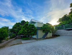 a white building with a tree in front of it at Mountain View Anilao in Mabini