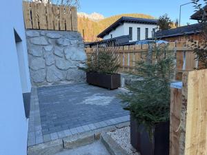 un cortile con recinzione e muro di pietra di Appartement Bergsicht a Leogang