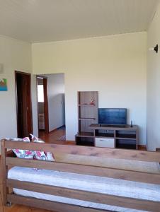 ein Wohnzimmer mit einer großen Bank vor einem Fernseher in der Unterkunft Apt 3 quartos sendo 1 suíte, zona sul de Ilhéus in Ilhéus