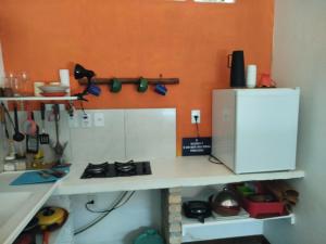 a kitchen with a white counter and a refrigerator at Cabanas Caraúbas II - ótimo visual do mar in Maxaranguape