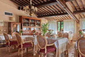 een eetkamer met tafels en stoelen en een kroonluchter bij Relais Osteria Dell'Orcia in Bagno Vignoni