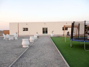 a white building with white chairs and a playground at Alharamil Retreat in Ras al Khaimah