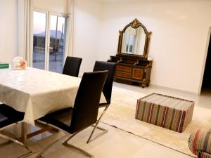 a dining room with a table and a mirror at Alharamil Retreat in Ras al Khaimah