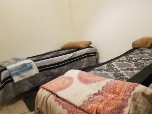 twee bedden staan tegen een muur bij Atlas Agdal Apartment in Rabat