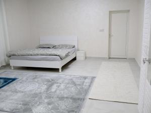 a white bedroom with a bed and a rug at Alharamil Retreat in Ras al Khaimah +29 photos