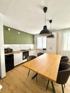 a large kitchen with a wooden table and chairs at TwinNest Petrila in Petrila