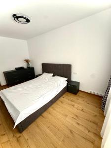 a bedroom with a large bed and a wooden floor at TwinNest Petrila in Petrila