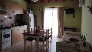 une cuisine avec une table et une cuisine avec une salle à manger dans l'établissement Apartamento Confortable Samai Huasi, à Las Grutas 21 autres photos